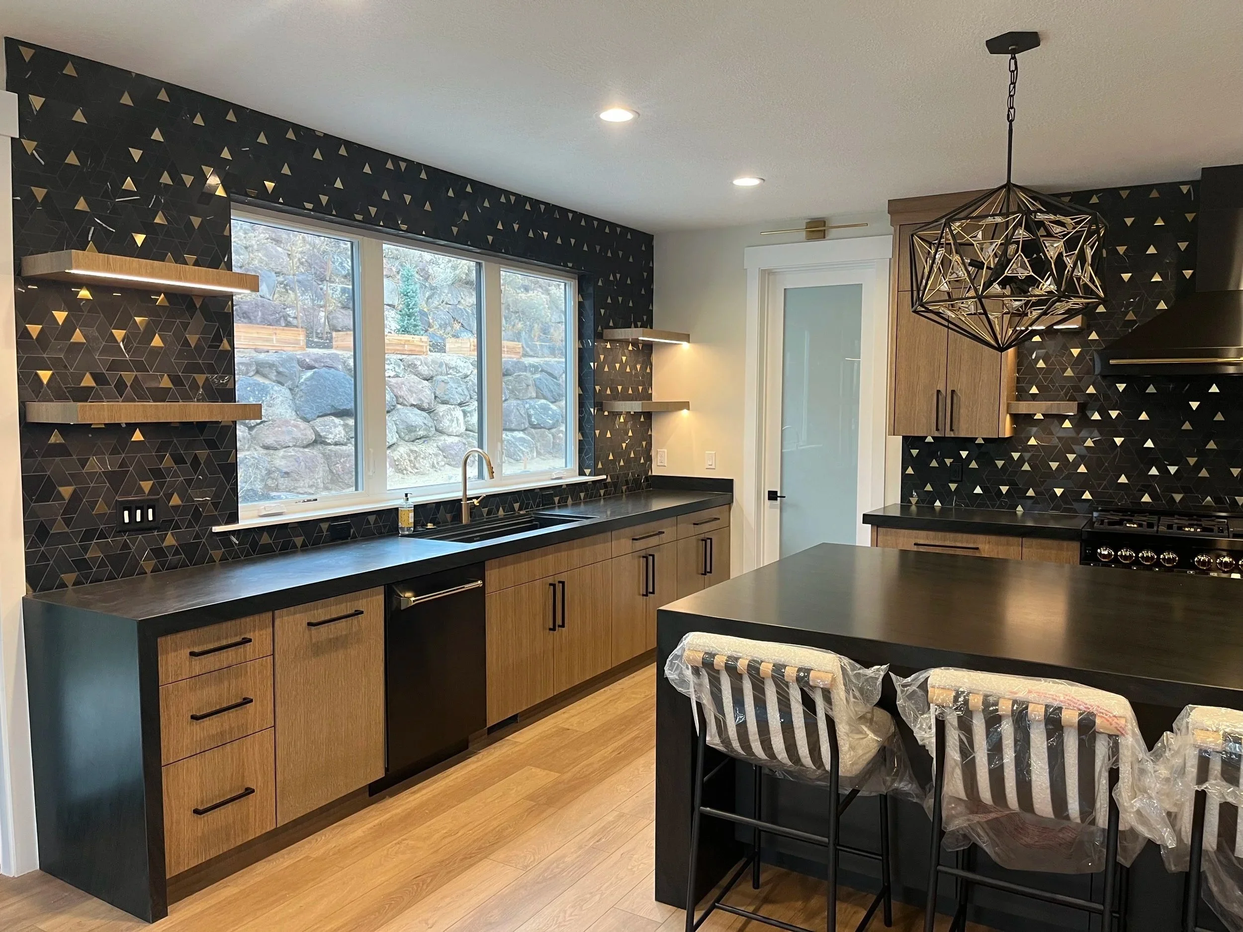Custom walnut and black kitchen with mountain views by Outlook Builders
