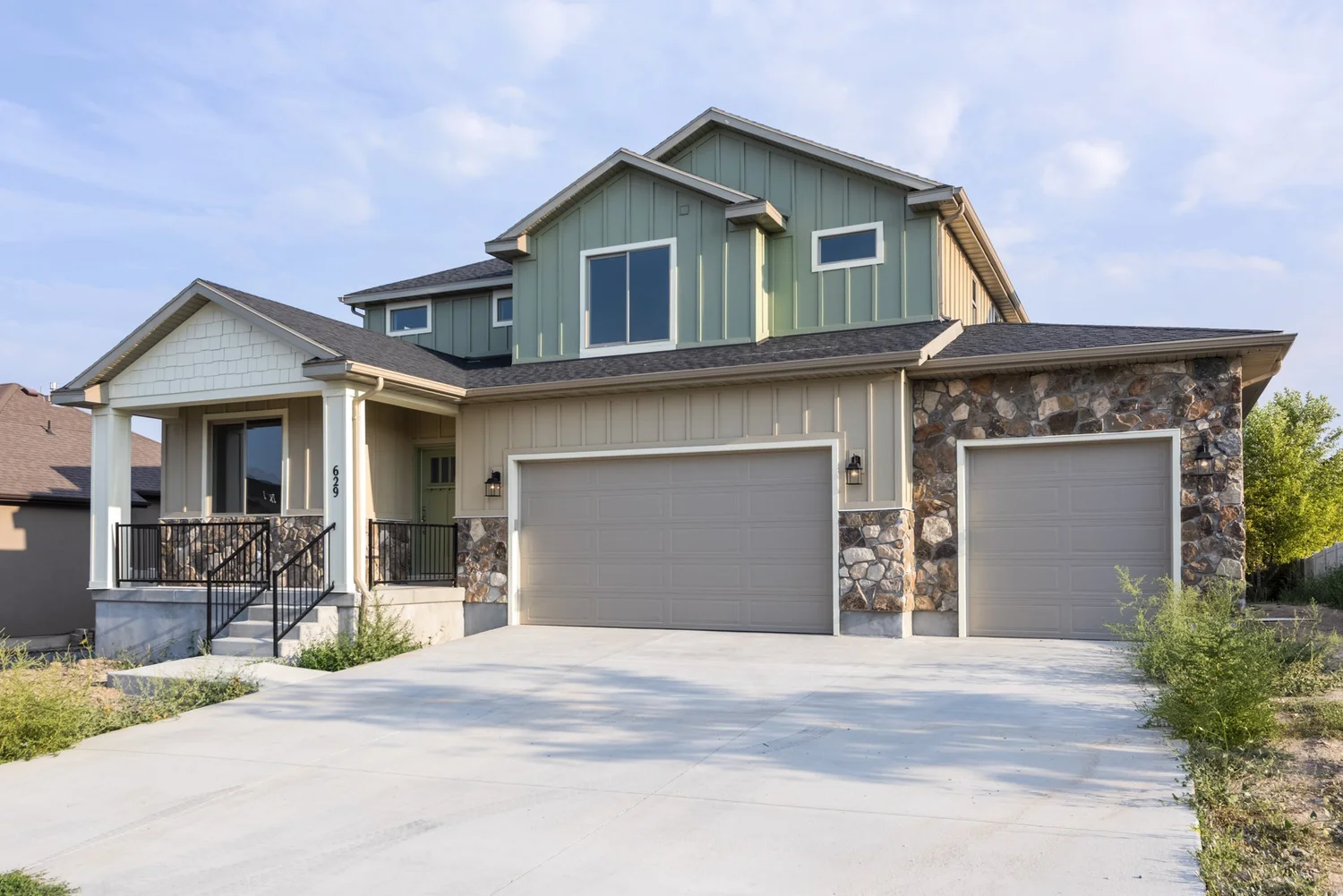 Custom Utah home with stone accents and deep porch, built by Outlook Builders