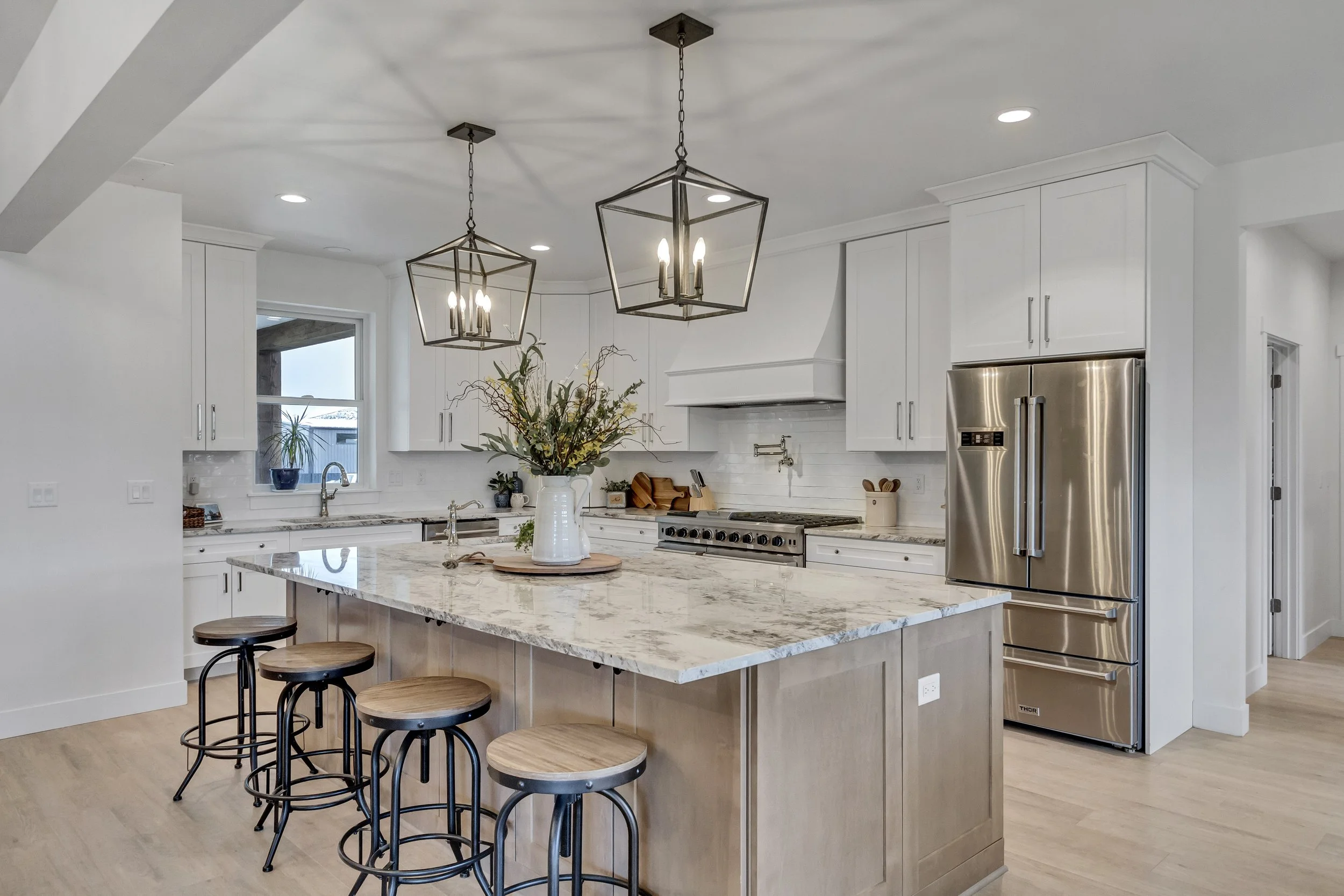 Bright custom kitchen with quartz island and lantern pendants